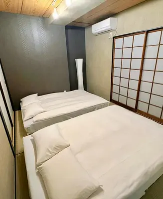 a room with three beds with white sheets at IKEBUKURO LoveSugamo \u4ea4\u901a\u4fbf\u5229 \u5c71\u624b\u7dda\u5de3\u9d28\u99c5\u5f92\u6b693\u5206 \u6c60\u888b\u99c54\u5206 2\u30fc4\u4eba \u30a8\u30ec\u30d9\u30fc\u30bf\u30fc WIFI \u65b0\u5bbf \u6e0b\u8c37 \u9280\u5ea7 \u6d45\u8349 \u9280\u5ea7 \u539f\u5bbf\u30a2\u30af\u30bb\u30b9\u4fbf\u5229 \u7a7a\u6e2f\u76f4\u901a in Tokyo