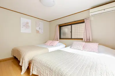 a bedroom with two beds and a window at NKm\u6625\u6c5f\u753a3\u4e01\u76ee in Tokyo