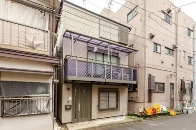 an apartment building with a balcony on a street at NKm\u6625\u6c5f\u753a3\u4e01\u76ee in Tokyo