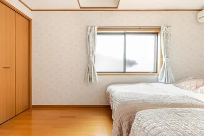 a bedroom with two beds and a window at NKm\u6625\u6c5f\u753a3\u4e01\u76ee in Tokyo