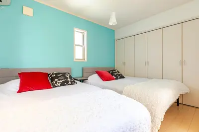 two beds in a room with blue walls at \u5927\u5cf65\u4e01\u76ee in Tokyo