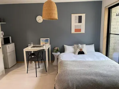 a bedroom with a bed and a table and a desk at COMMA HOUSE Kitaikebukuro 202 in Tokyo