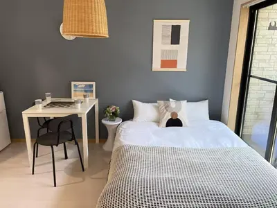a bedroom with a bed and a desk with a laptop at COMMA HOUSE Kitaikebukuro 202 in Tokyo