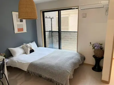 a bedroom with a bed and a large window at COMMA HOUSE Kitaikebukuro 202 in Tokyo