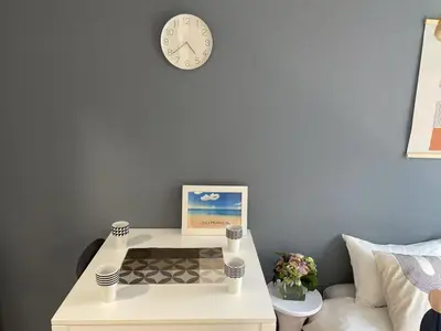 a white table with a clock on a wall at COMMA HOUSE Kitaikebukuro 202 in Tokyo