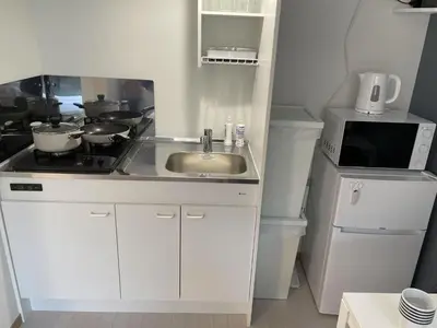 a small kitchen with a sink and a microwave at COMMA HOUSE Kitaikebukuro 202 in Tokyo