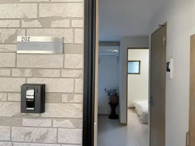 a bathroom with a brick wall with a paper towel dispenser at COMMA HOUSE Kitaikebukuro 202 in Tokyo
