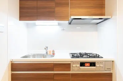 a kitchen with wooden cabinets and a sink at \u4eac\u5cf63\u4e01\u76ee\u8cb8\u6238\u5efa in Tokyo