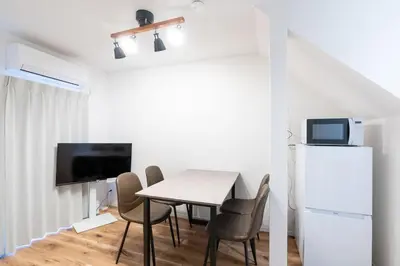 a dining room with a table and a refrigerator at \u4eac\u5cf63\u4e01\u76ee\u8cb8\u6238\u5efa in Tokyo