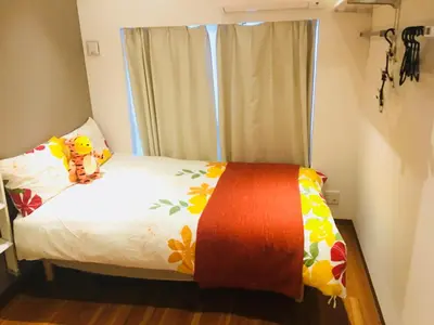 a bedroom with a bed with a teddy bear on it at Okubo House 3F SJ0277 in Tokyo