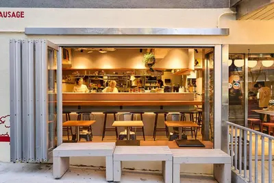a restaurant with a bar with tables and chairs at Dogen sauna&stay in Tokyo