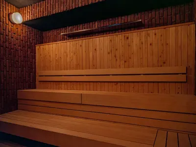a sauna with wooden benches and a light fixture at Dogen sauna&stay in Tokyo