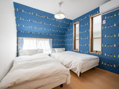 two beds in a room with blue walls at FAMILIA OMORIKAIGAN - Vacation STAY 18448 in Tokyo