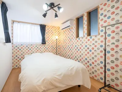 a bedroom with a white bed and a wall with polka dots at FAMILIA OMORIKAIGAN - Vacation STAY 18448 in Tokyo