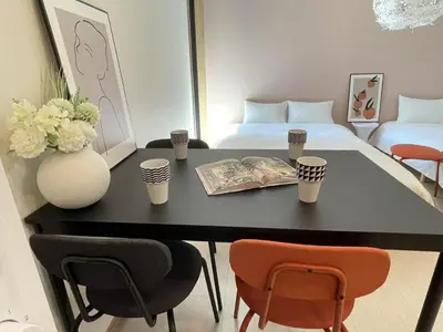 a room with a table with chairs and a bed at COMMA HOUSE Kitaikebukuro 203 in Tokyo