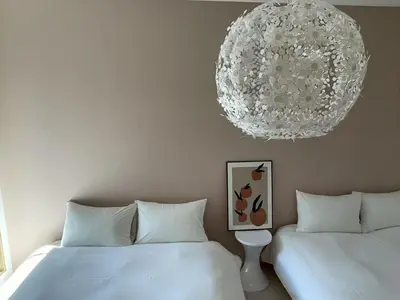a bedroom with two beds and a chandelier at COMMA HOUSE Kitaikebukuro 203 in Tokyo