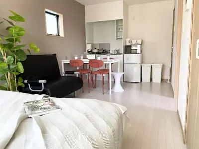 a living room with a bed and a kitchen at COMMA HOUSE Kitaikebukuro 301 in Tokyo