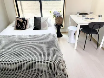 a bedroom with a bed and a desk and a table and chairs at COMMA HOUSE Kitaikebukuro 302 in Tokyo
