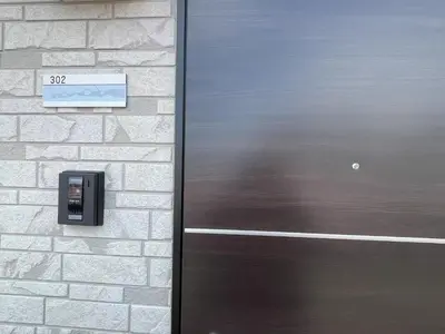 a metal door on the side of a brick building at COMMA HOUSE Kitaikebukuro 302 in Tokyo