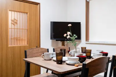 a dining room table with chairs and a television at 4-chome House Senju 1F - Cozy Japanese-Style Apartment, 8 min to Kita-Senju in Tokyo