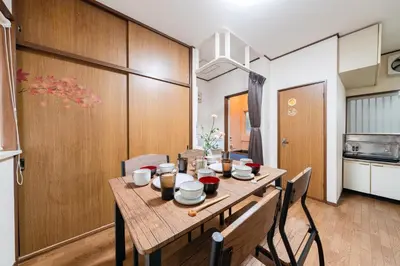 a dining room with a wooden table and chairs at 4-chome House Senju 1F - Cozy Japanese-Style Apartment, 8 min to Kita-Senju in Tokyo