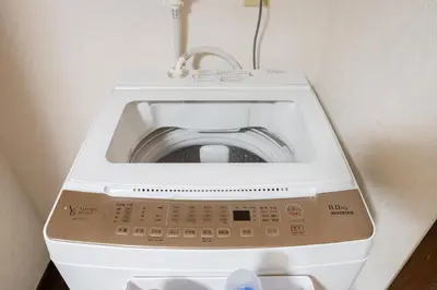 a washing machine sitting in a corner of a room at 4-chome House Senju 1F - Cozy Japanese-Style Apartment, 8 min to Kita-Senju in Tokyo