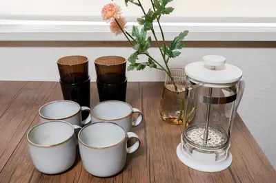 a group of coffee cups and a blender on a table at 4-chome House Senju 1F - Cozy Japanese-Style Apartment, 8 min to Kita-Senju in Tokyo