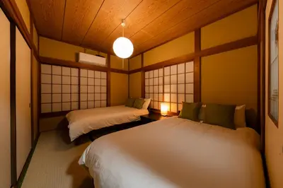a room with two beds and two windows at 4-chome House Senju 1F - Cozy Japanese-Style Apartment, 8 min to Kita-Senju in Tokyo