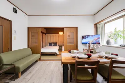a living room with a table and a bedroom at 4-chome House Senju 2F - Cozy Japanese-Style Apartment, 8 min to Kita-Senju in Tokyo