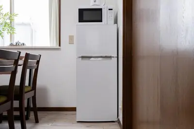a white refrigerator with a microwave on top of it at 4-chome House Senju 2F - Cozy Japanese-Style Apartment, 8 min to Kita-Senju in Tokyo