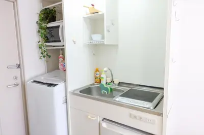a kitchen with a sink and a refrigerator at \u30cf\u30a4\u30af\u30ec\u30b9\u30c8\u4e2d\u91ce101 in Tokyo