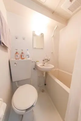 a white bathroom with a toilet and a sink at \u30cf\u30a4\u30af\u30ec\u30b9\u30c8\u4e2d\u91ce101 in Tokyo