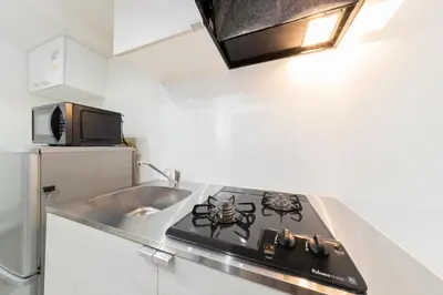 a stove top in a kitchen with a sink at Tsubaki in Tokyo