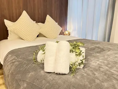 a bed with two rolled towels on it at Ikebukuro Area 2 Units NishiikeApartment in Tokyo
