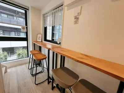 a bar in a room with a window and stools at W-inns Asakusabashi in Tokyo