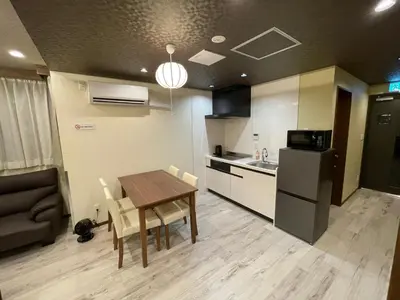a kitchen and dining room with a table and a refrigerator at \u304a\u5bbf\u5be7\u3005\u6771\u4eac\u5e73\u548c\u5cf6 \u99c54\u5206 \u7fbd\u7530\u7a7a\u6e2f15\u5206 in Tokyo
