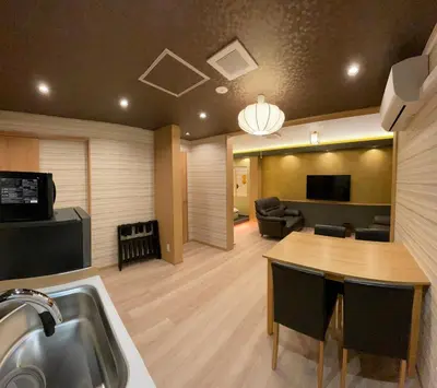 a kitchen and living room with a table and a couch at \u304a\u5bbf\u5be7\u3005\u6771\u4eac\u5e73\u548c\u5cf6 \u99c54\u5206 \u7fbd\u7530\u7a7a\u6e2f15\u5206 in Tokyo