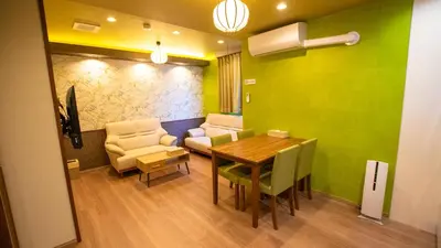a dining room with a table and a couch and chairs at \u304a\u5bbf\u5be7\u3005\u6771\u4eac\u5e73\u548c\u5cf6 \u99c54\u5206 \u7fbd\u7530\u7a7a\u6e2f15\u5206 in Tokyo