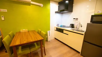 a small kitchen with a wooden table and a sink at \u304a\u5bbf\u5be7\u3005\u6771\u4eac\u5e73\u548c\u5cf6 \u99c54\u5206 \u7fbd\u7530\u7a7a\u6e2f15\u5206 in Tokyo