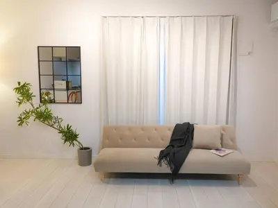 a couch in a living room with a window at OPEN! TOKYO Kitasenju A Newly built stylish room! in Tokyo