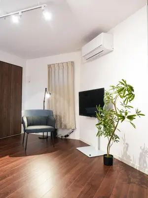 a living room with a chair and a tv at OPEN! TOKYO Kitasenju A Newly built stylish room! in Tokyo