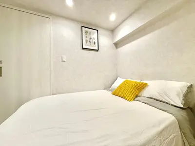 a bedroom with a white bed with a yellow pillow at \u6771\u65b0\u5bbf\u99c5\u65b0\u5bbf4\u4eba\u53ef b2 in Tokyo