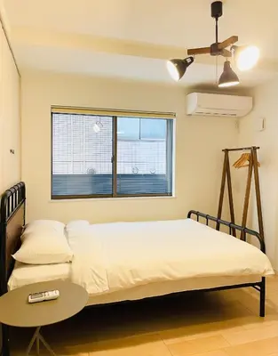 a bedroom with two beds and a table at Alo BnB 7 - Near IKEBUKURO, SHINJUKU, UENO - Self Check in - OYAMA Sta 3min in Tokyo