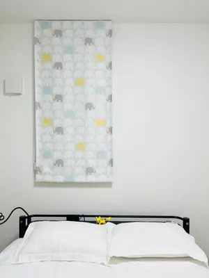 a bedroom with a bed with white sheets and a painting at Alo BnB 7 - Near IKEBUKURO, SHINJUKU, UENO - Self Check in - OYAMA Sta 3min in Tokyo