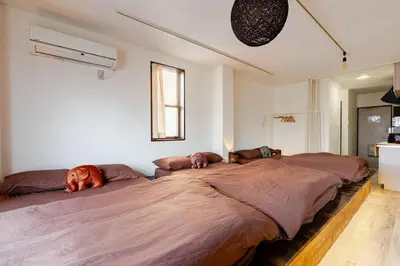 a bedroom with a large bed with pillows on it at Pro Kitchen and Karaoke 100sqm amusement hotel in Tokyo