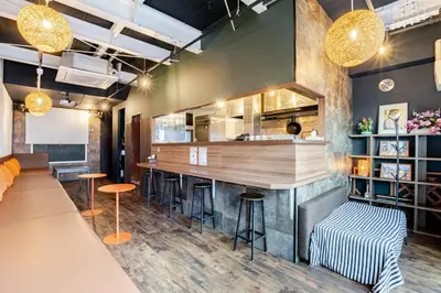 a bar in a restaurant with stools and a counter at Pro Kitchen and Karaoke 100sqm amusement hotel in Tokyo