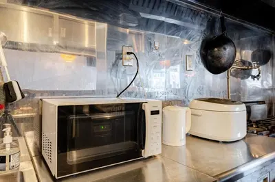 a microwave sitting on a counter in a kitchen at Pro Kitchen and Karaoke 100sqm amusement hotel in Tokyo