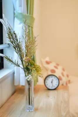 a vase with flowers and a clock on a table at YXD301 Direct Skytree convenience facilities in Tokyo