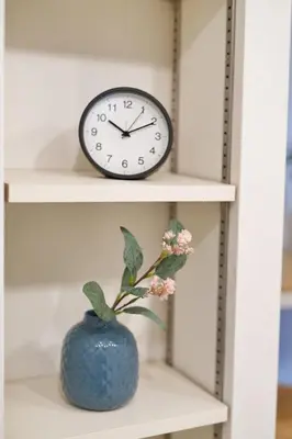 a clock on a shelf with a vase with a flower at YXD302 Direct Skytree convenience facilities in Tokyo