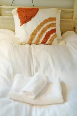 a white bed with a pile of towels on it at YXD501 Direct Skytree convenience facilities in Tokyo
